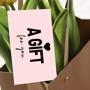 Detail of pink gift card with heart and A GIFT for you text in tulip flower packaging