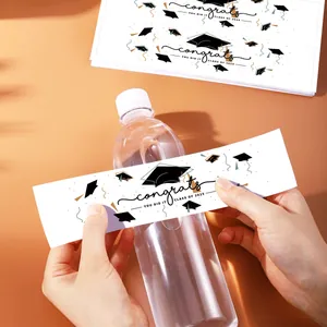 Detalle de etiquetas para botellas de agua de graduación 2025 con confeti dorado y birrete