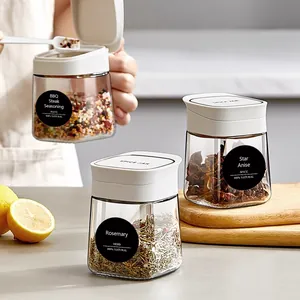 Set di barattoli per spezie in vetro con etichette nere e tappi bianchi su legno naturale