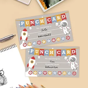 Macro shot of space-themed student punch cards with planets and rockets on a desk