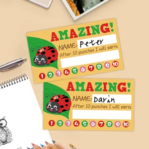 Detailed view of yellow cartoon ladybug reward punch cards on a desk with stationery