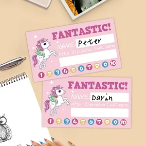 Close-up of pink unicorn punch cards with slots for rewards on a creative desk