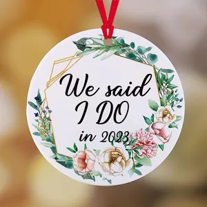 Detail van 'We said I DO in 2023' tekst op een florale keramische kersthanger met lint