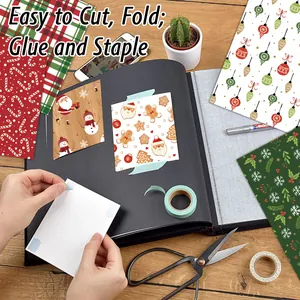 Christmas scrapbook paper kit with red candy canes and holiday patterns on a wooden desk