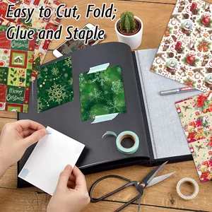 Christmas scrapbook paper collection with festive patterns on a rustic wooden desk setup