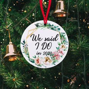 Detail van een ronde bloemen kersthanger 2023 hangend aan een feestelijk versierde boom