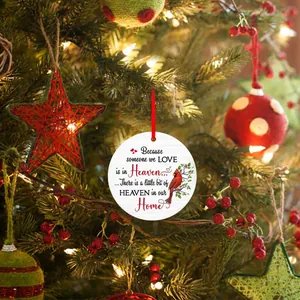 Close-up of a memorial Christmas ornament with a red cardinal bird on a lit tree branch