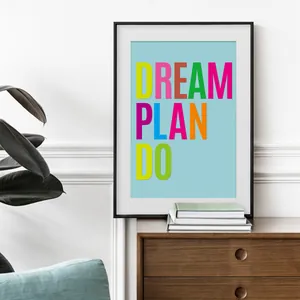 Modern framed wall art with colorful Dream Plan Do lettering on a light blue background