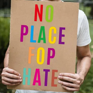 Close-up of colorful 'NO PLACE FOR HATE' stickers on craft paper texture for DIY decor