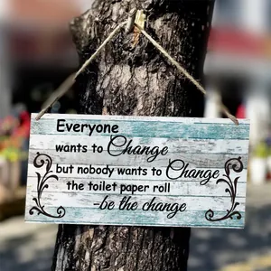 Outdoor close-up of a rustic wooden sign with funny bathroom text on a tree trunk