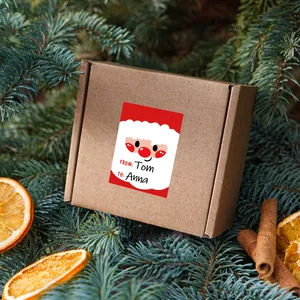 Christmas gift name labels on kraft paper box with festive decorations and pine needles