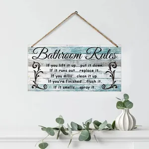 Detail of rustic wooden Bathroom Rules sign with twine hanger on white wall