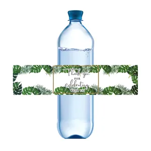 Detalle de etiquetas de botellas de agua con hojas tropicales y mensaje de agradecimiento boda