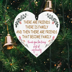 Close-up of heart-shaped wooden plaque with sentimental quote on a Christmas tree