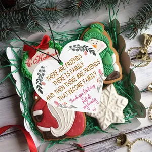 Close-up of heart wooden ornament with sentimental quote and Christmas decor
