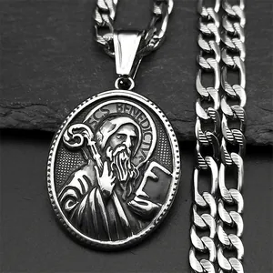 Vue macro du pendentif Saint Benoît avec finition vintage sur un fond de pierre noire
