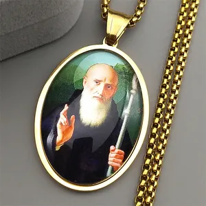 Macro shot of gold St. Benedict oval medallion pendant with saint portrait and chain