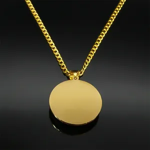 Detail van een goudkleurige schakelketting met een gladde ronde hanger van staal