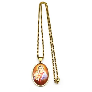 Macro detail of golden stainless steel oval pendant with Virgin Mary and Child painting