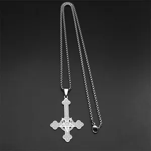 Macro shot of silver inverted cross pendant with pentagram detail on a steel box chain