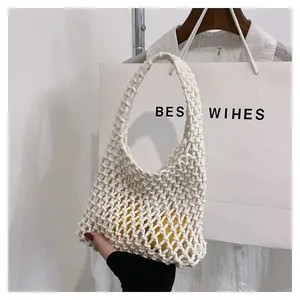 Detail of white handmade woven net bag featuring hollow mesh knots and a comfortable handle