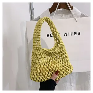 Detail of a bright yellow hand-woven cotton rope mesh bag with a hollow hollow-out design