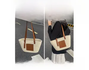 Detail showing straw woven tote bag in beige with brown leather straps and patch