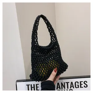 Close-up of black handmade woven crochet tote bag with hollow mesh texture and sturdy handle