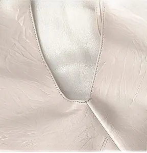 Close-up of fine stitching on the V-neckline with pleated satin texture fabric