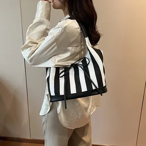 Minimalist striped PU tote bag with bow detail and leather trim for women's daily commute