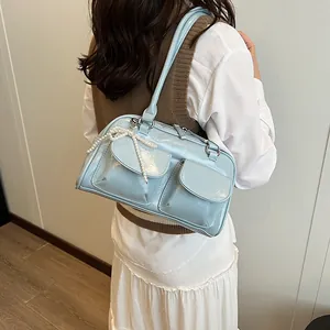 Pale blue patent leather shoulder bag with double front pockets and pearl bow charm