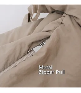 Detail van zilveren metalen rits op kaki nylon halve maan tas met gerimpelde textuur