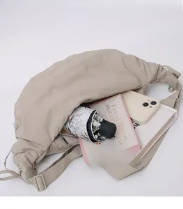 Detailed interior storage view of the beige crescent crossbody bag with daily essentials