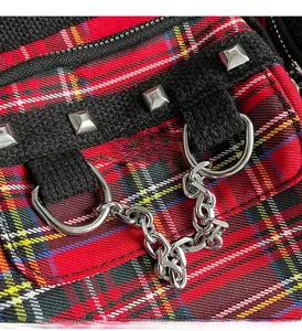 Close-up of tartan plaid fabric with silver studs and a bold metal chain detail