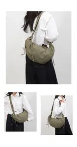 Detail view of olive green crescent hobo bag with nylon texture and adjustable strap
