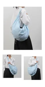 Macro-detail van een lichtblauwe geplooide schoudertas met breed bandontwerp