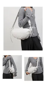 Detailed view of a white pleated dumpling bag with side drawstring and adjustable strap