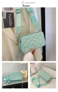 Detail of mint green quilted crossbody bag with rainbow texture and wide fabric strap