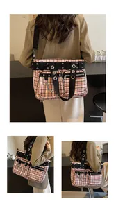 Close-up of pink checkered tote bag with punk metal eyelets and decorative chains