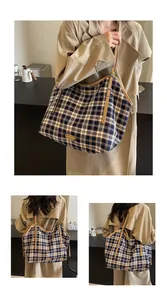 Detail of navy plaid canvas tote bag with brown leather straps and spacious interior