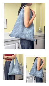 Detailed close-up of blue wash textured tote bag with unique geometric origami construction