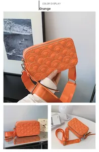 Detail of orange rectangular crossbody bag featuring unique semi-circular wave quilting