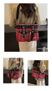 Detail showing red plaid fabric, punk style metal eyelets, and silver chain on tote bag