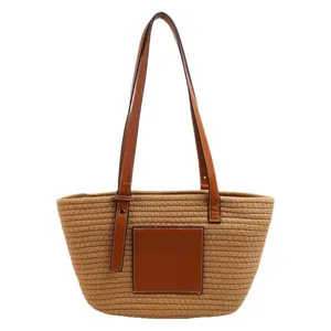 Large khaki straw tote bag with brown leather patch and long handles for beach or travel