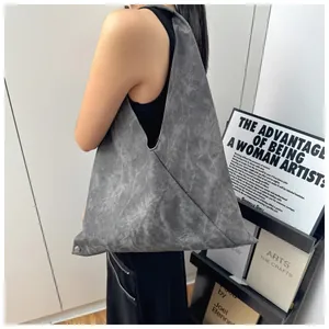 Detail shot of a grey triangular tote bag with marble texture and metal eyelet accents