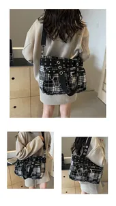 Close-up of black and white plaid tote bag with zipper pockets and metal chain detail