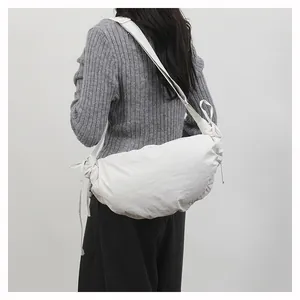 Detailed back view of a white slouchy dumpling bag with side drawstrings on a model