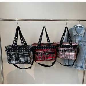 Detail of plaid tote bags with metal eyelets and double front pockets on hangers
