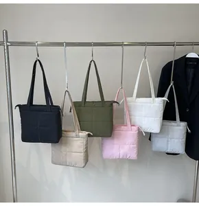 Quilted tote bags in multiple colors displayed on a metal rack for daily commute