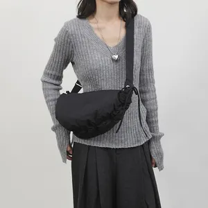 Minimalist black pleated dumpling bag in nylon with adjustable shoulder strap